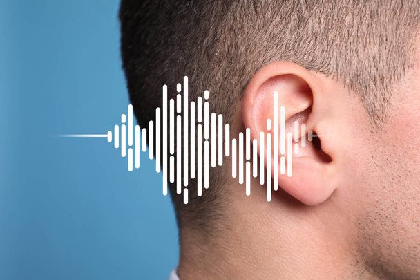Hearing loss concept. Man and sound waves illustration on light blue background, closeup - 写真・画像