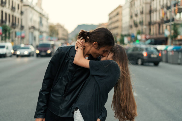 Young man kissing his girlfriend in the middle of the street - Foto, Bild