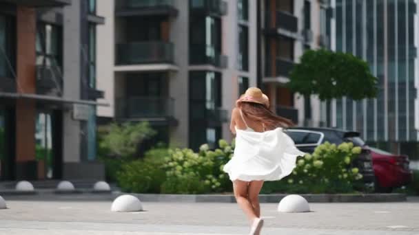 若い美しいブルネットの女性が街を歩くドレス、夏の堤防屋外 - 映像、動画