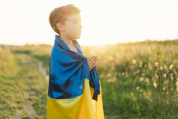 Ukrajinská dívka zavřela oči a modlila se, aby při západu slunce zastavila válku na Ukrajině. Ruce složené v modlitební koncepci pro víru, spiritualitu a náboženství. Válka Ruska proti Ukrajině. Zastavit válku - Fotografie, Obrázek