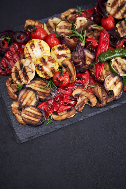 Grilled vegetables mix on a stone serving board - zucchini eggplant onions corn mushroom tomato. - Zdjęcie, obraz