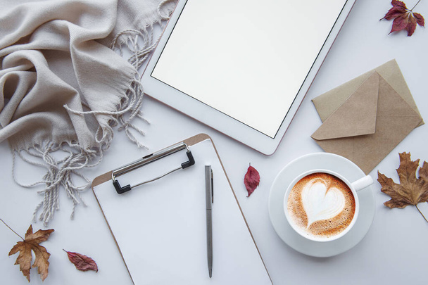 Home workplace. Cup of coffee and tablet, leaves and warm blanket.  Autumn, fall concept. Flat lay, top view. - Photo, Image