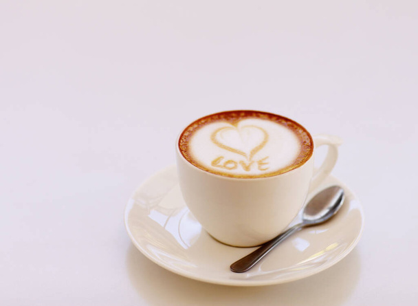 Fabriqué avec amour à l'esprit... Plan grand angle d'une tasse de cappuccino amoureusement préparé assis sur une table de café - Photo, image