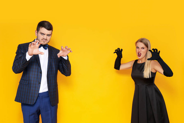 Concept of Halloween, young man and woman on yellow background - Photo, Image