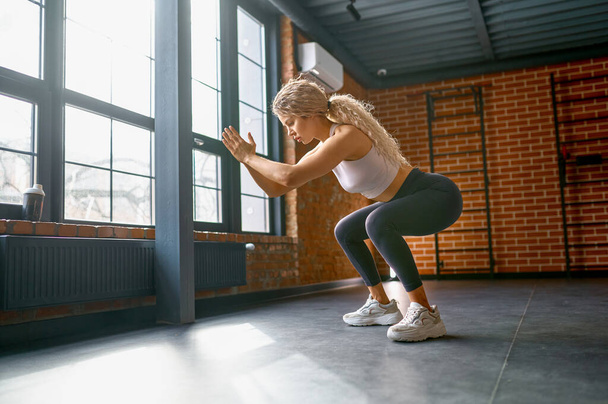 Donna che allena i muscoli delle gambe con esercizi di salto e squat. Concetto di benessere e power practice - Foto, immagini