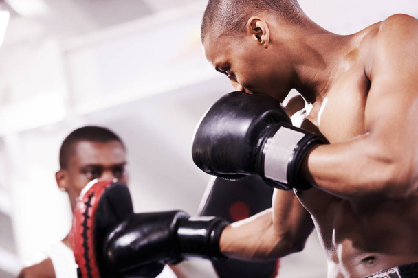 Keep up. A boxer practicing with his sparring partner in the ring - 写真・画像