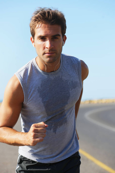 Garder mon corps en forme et en bonne santé. beau jeune jogger courir avec une tache de sueur sur sa chemise - Photo, image