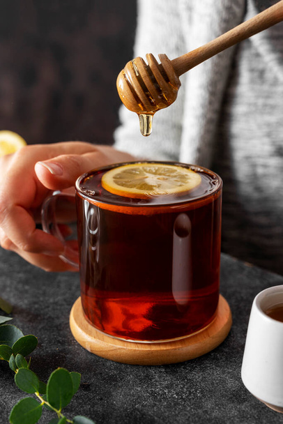 Black tea in glass cup, morning hot drink with lemon and honey - Fotoğraf, Görsel