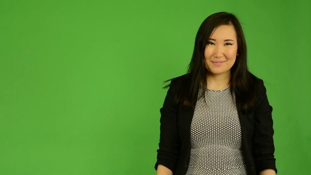 Young attractive asian woman show up and smiles - green screen studio - Footage, Video