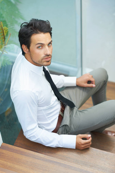 Eine Pause einlegen. Ein hübscher junger Geschäftsmann sitzt auf einer Treppe - Foto, Bild