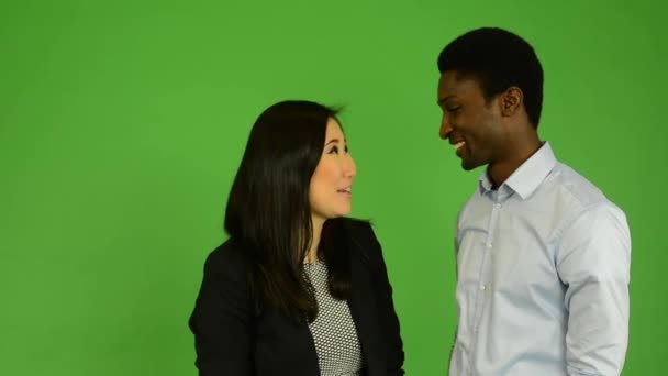 Šťastný pár mluvit (rozhovor) - černoch a asijské ženy - zelené obrazovky studio - Záběry, video