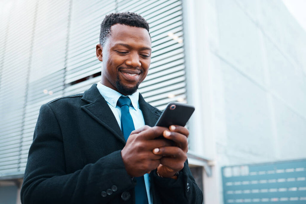 Phone, happy black man and business in city, street or outdoors on social media, web browsing or text message. Employee, entrepreneur and male in Nigeria internet surfing or research on 5g mobile app. - Photo, image