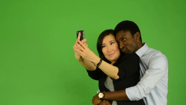 feliz pareja tomar foto - negro hombre y asiático mujer - verde pantalla de estudio
 - Imágenes, Vídeo