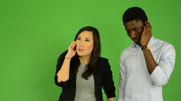 Feliz pareja teléfono - hombre negro y mujer asiática - estudio de pantalla verde
 - Metraje, vídeo