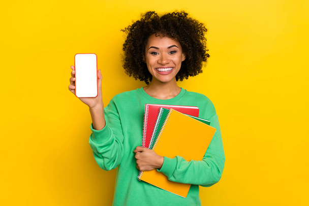 Portrait of positive nice lady demonstrate empty space phone display isolated on yellow color background. - Foto, Bild