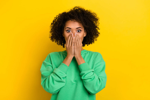 Photo of charming shocked young lady dressed green sweater arms close mouth isolated yellow color background. - Foto, Imagem