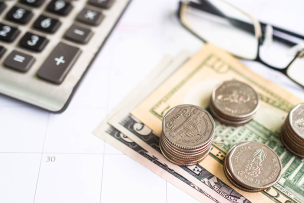 Stack Coin on Bank Note with Blur Calculator and glasses on white Table Background, Επενδυτικό Εισόδημα και Εξοικονόμηση για το 2023. - Φωτογραφία, εικόνα