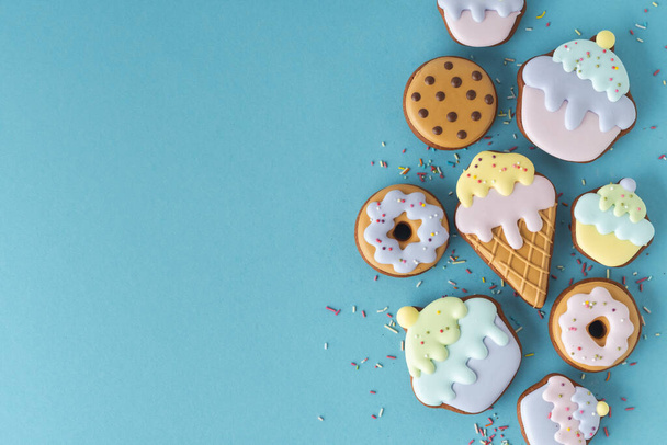 Домашнє пряникове печиво у формі морозива з пастельними кольорами. Вінтажний стильний день народження випічки фон. Вільний простір для тексту. Плоский лежав з синім тлом
 - Фото, зображення