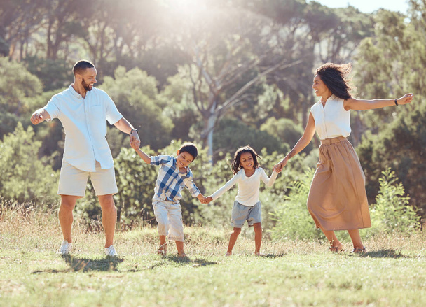 Свобода, счастливая семья и веселье в парке с черными детьми и родителями, сближающимися и играющими на траве. Любовь, энергия и дети взволнованы и счастливы, наслаждаясь веселыми танцами с мамой и папой. - Фото, изображение