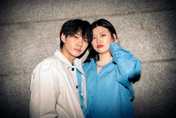 Young asian woman with blue eyes posing and looking at camera next to her boyfriend. - Φωτογραφία, εικόνα