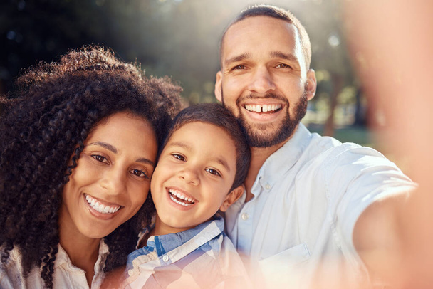 Portrait, selfie and happy family in a park, relax and smiling while taking a picture and bonding in nature. Love, smile and face of excited kid enjoying quality time with loving, caring mom and dad. - Foto, Imagen