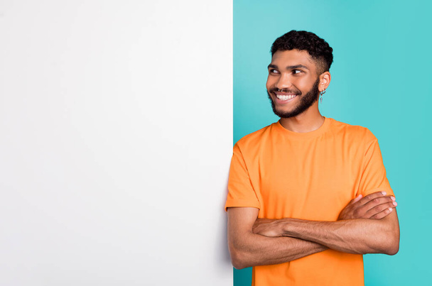 Portrait of cheerful person folded arms toothy smile look interested empty space isolated on teal color background. - Фото, изображение