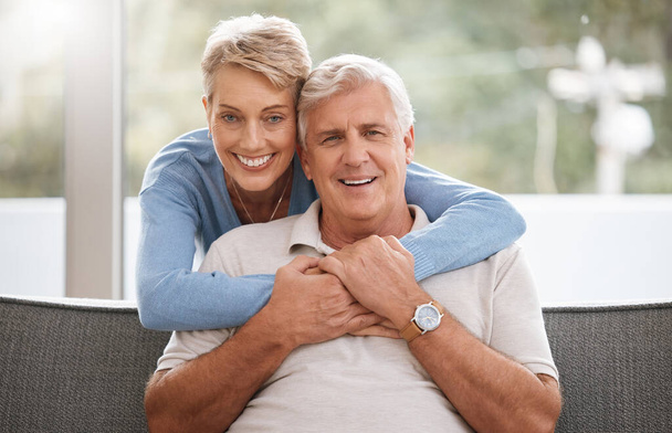Happy senior couple in living room portrait with love, care and support hug in home living room. Dallas elderly or pension people relax on sofa together and happiness with life wellness or retirement. - Фото, зображення