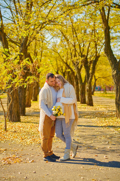 妊婦と男抱擁で日当たりの良い秋の公園 - 写真・画像