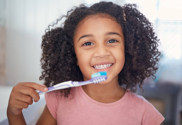 Young girl kids, portrait and brushing teeth, dental healthcare and bathroom toothbrush in Brazil home. Happy, smile and black child face cleaning mouth, healthy wellness development and fresh breath. - Photo, Image