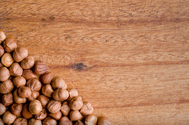 Chopping board with line of hazelnuts. - Foto, immagini
