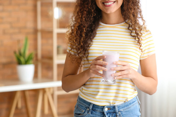 Young African-American woman with healthy yogurt at home. Diet concept - Valokuva, kuva