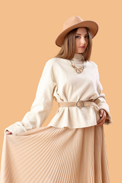 Beautiful fashionable young woman on beige background - Fotografie, Obrázek