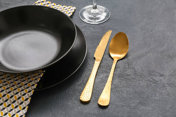 Elegant table setting with golden cutlery on dark background, closeup - Foto, Imagem