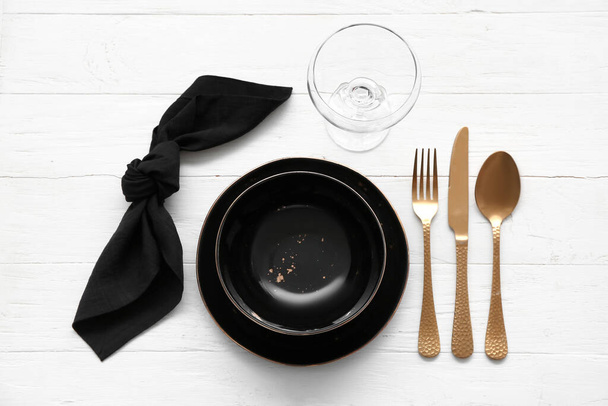 Stylish table setting with golden cutlery on light wooden background - Photo, image