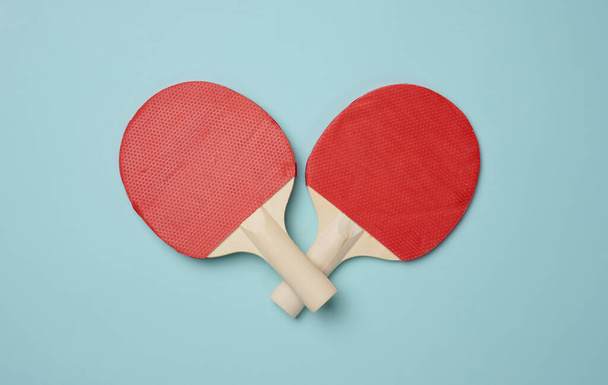 Par de raquetas de tenis de madera para ping pong sobre fondo azul, vista superior - Foto, imagen