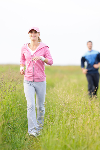 Jogging sportive young couple running meadow field - Foto, imagen