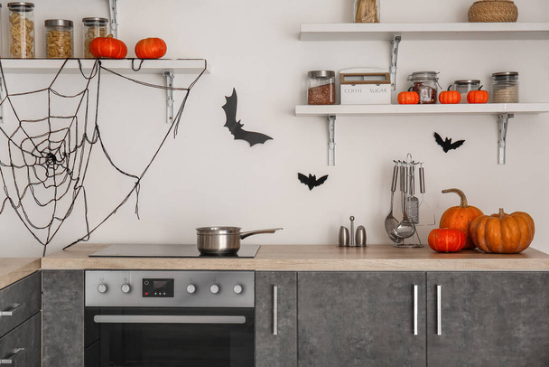 Интерьер современной кухни украшен на Хэллоуин тыквами и полками - Фото, изображение