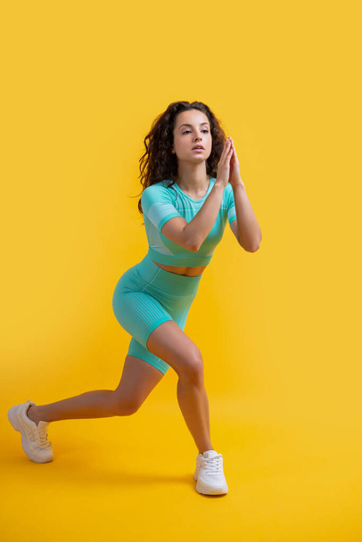 sport woman do lunge exercise at studio. sport woman doing lunge exercise isolated on yellow background. sport lunge exercise. - Foto, Imagen