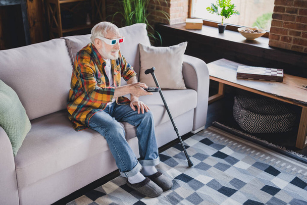 Photo of funny funky retired man wear checkered shirt watching 3d movie sitting couch indoors apartment room. - Photo, Image