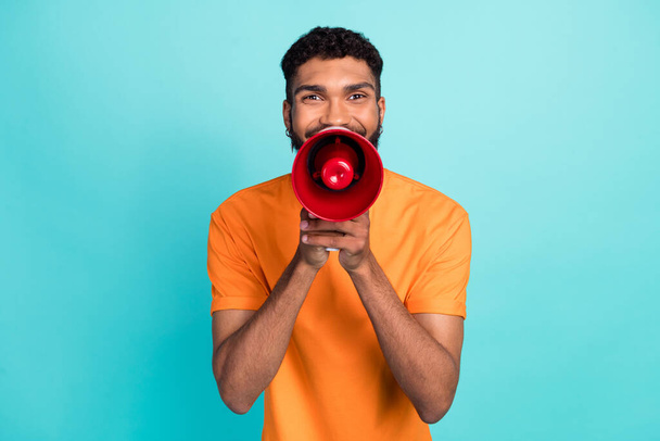 Photo of funky funny man dressed orange t-shirt making announcement loudspeaker isolated turquoise color background. - Zdjęcie, obraz