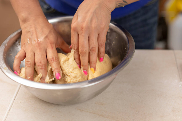 womans mains pétrissant ingrédients pour faire pan de muerto - Photo, image
