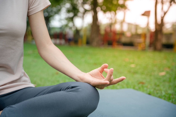 Młoda szczupła kobieta ćwicząca jogę w parku. Dziewczyna robi ćwiczenia rano. równowaga, medytacja, relaks, koncepcja zdrowego stylu życia - Zdjęcie, obraz