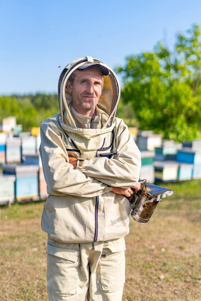 Professional beekeeper in bee suit. Agriculture honey farming. - 写真・画像
