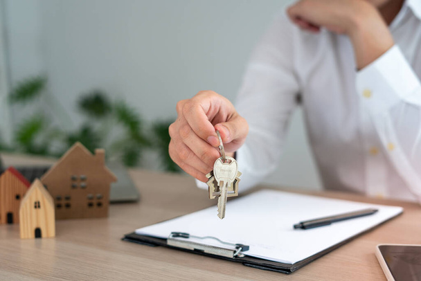 selling home. House sales agents send home keys to customers. The merchant closes the deal successfully after the customer agrees to sign the contract. - Foto, Imagem