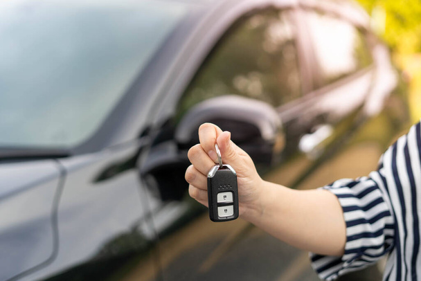 An employee of a tourist car rental company presents the car keys with a test drive. Good service before agreeing to a lease or purchase contract. - Foto, immagini