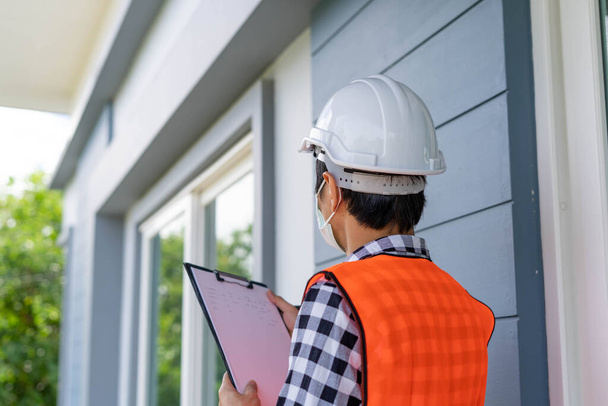 Inspector or engineer is checking and inspecting the building or house by using checklist. Engineers and architects work on building the house before handing it over to the landlord. - Photo, Image
