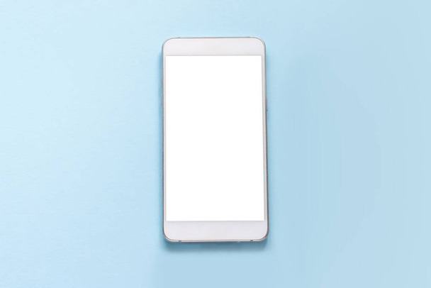 Λευκό smartphone με λευκή άδεια οθόνη θέσει σε ένα μπλε φόντο mockup. πάνω όψη - Φωτογραφία, εικόνα