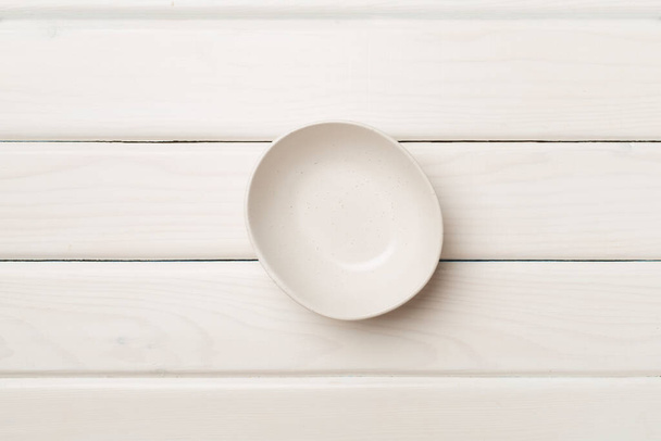 Empty round plate on wooden background, top view. - Foto, afbeelding