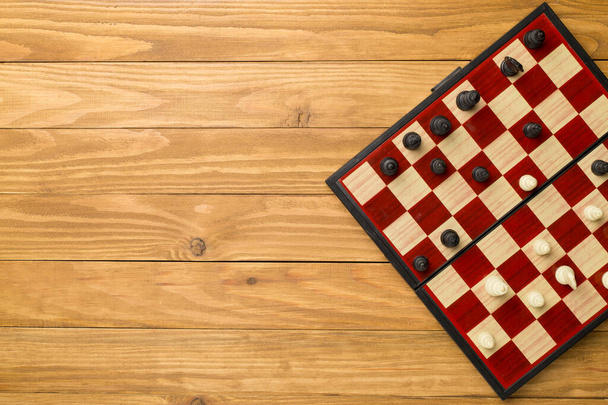 Шахматы на деревянном фоне, вид сверху. - Фото, изображение