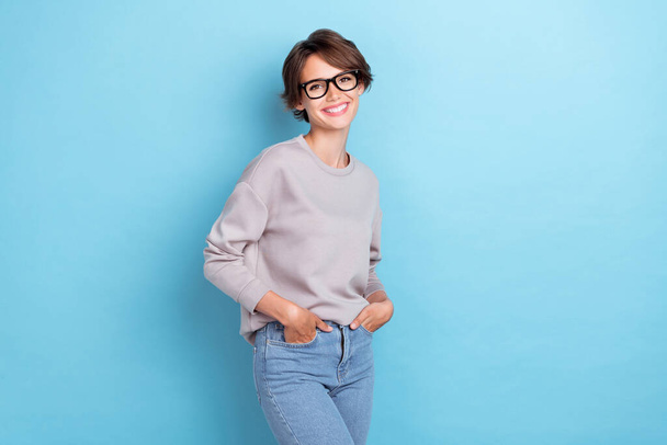 Photo of lovely cheery sweet lady trendy eye accessory nice outfit pullover hand pocket empty space isolated on blue color background. - Foto, Bild
